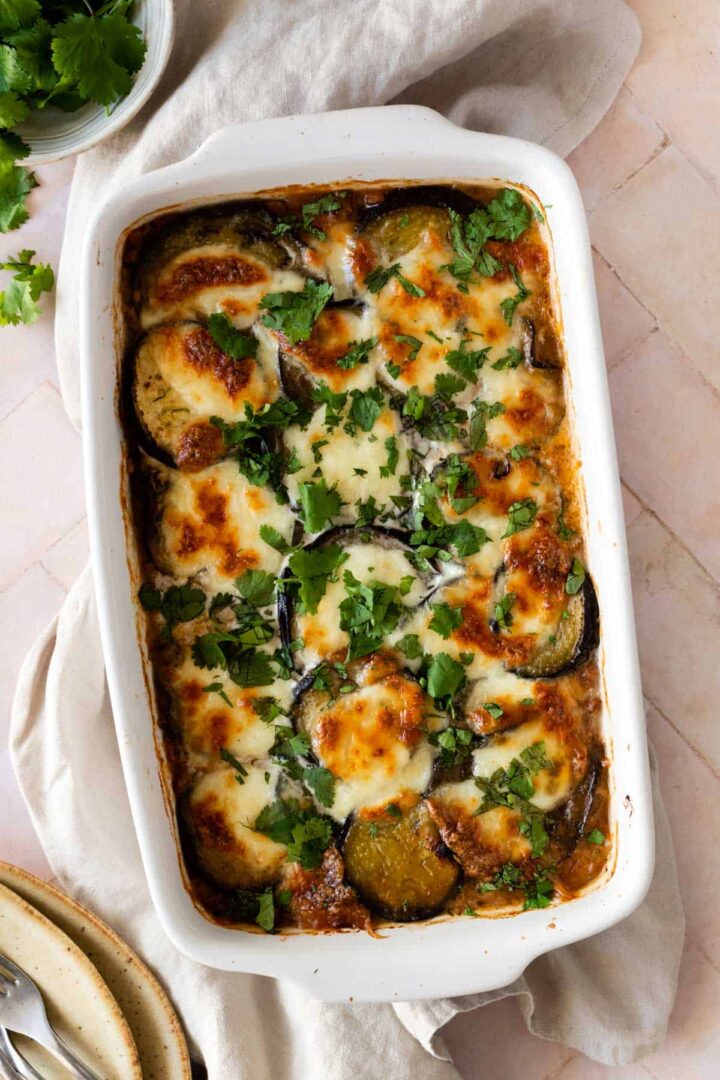 a baking dish with vegetable moussaka with chopped coriander on top