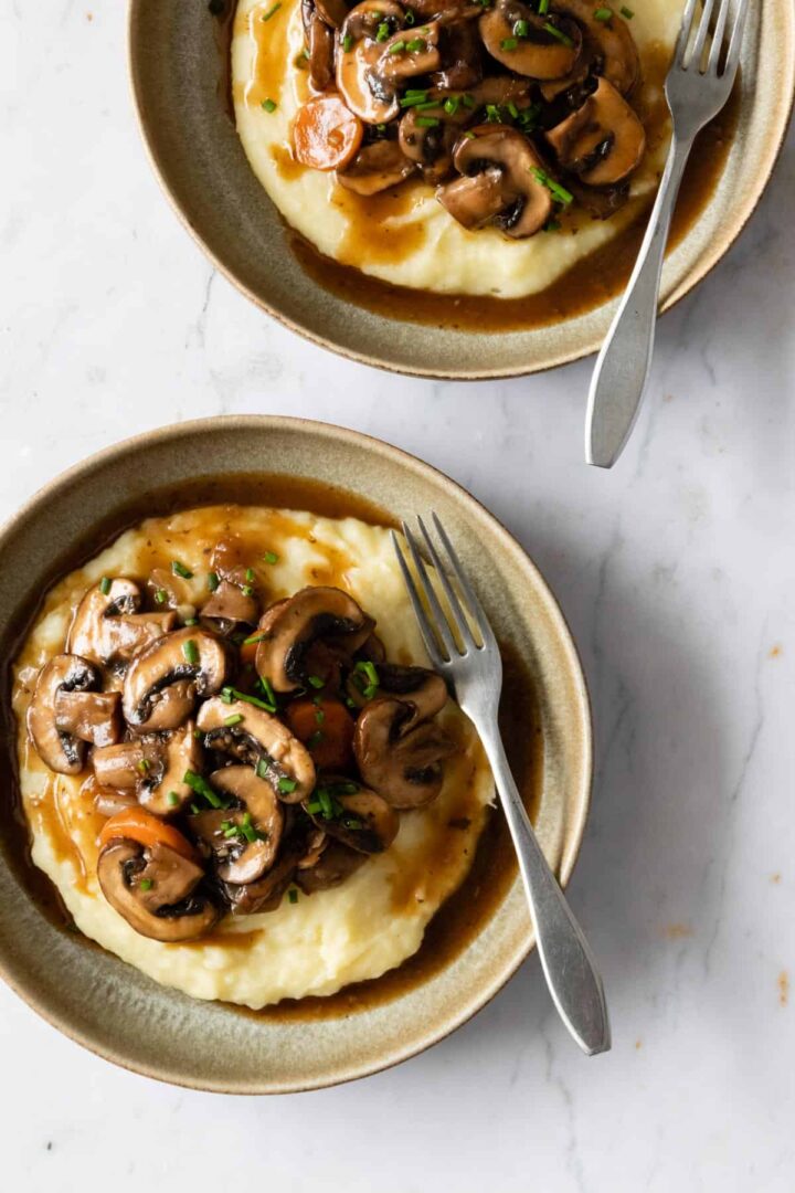 two plates served with mashed potatoes and mushroom bourguignon