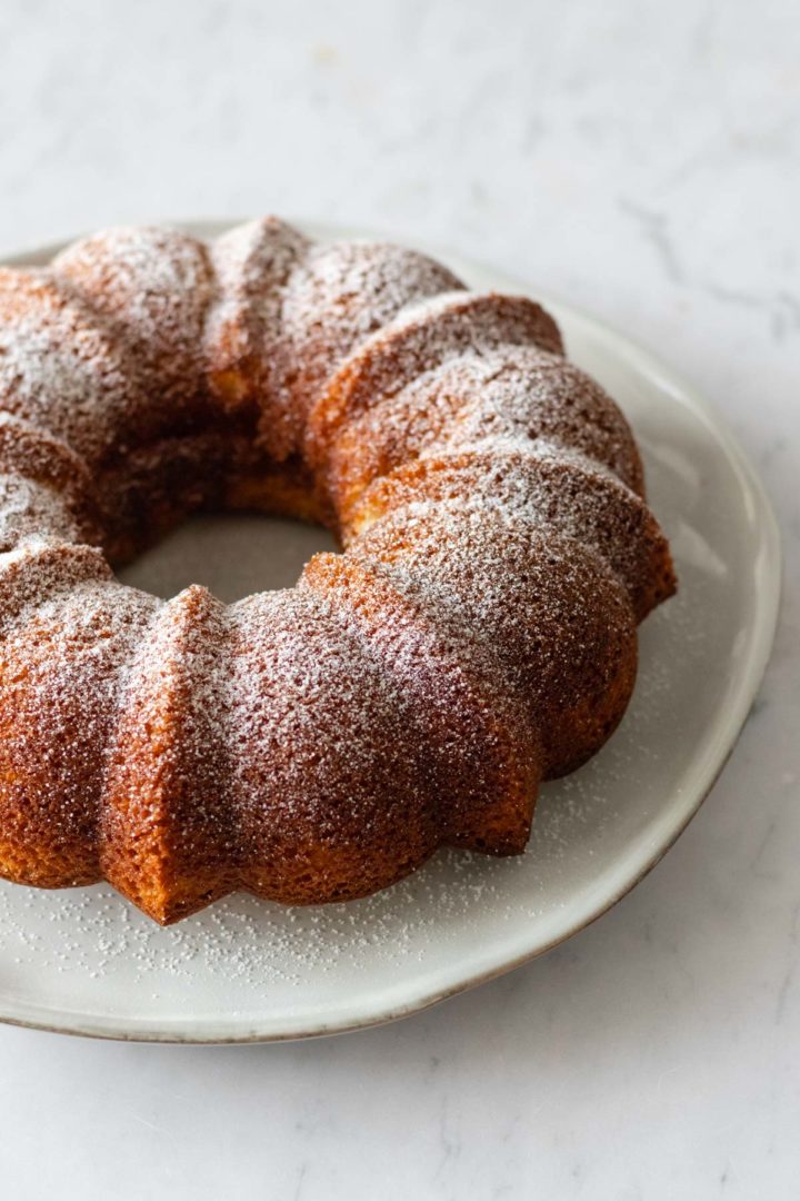 a yogurt cake on a plate with powdered sugar on top