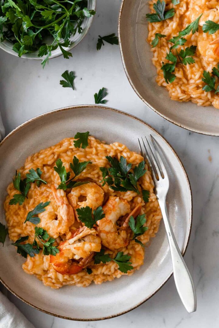 a plate served with shrimp risotto garnished with parsley