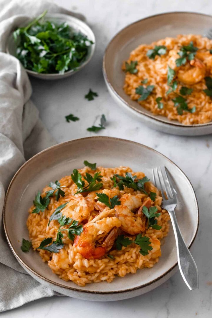 two plates served with shrimp risotto and garnished with parsley