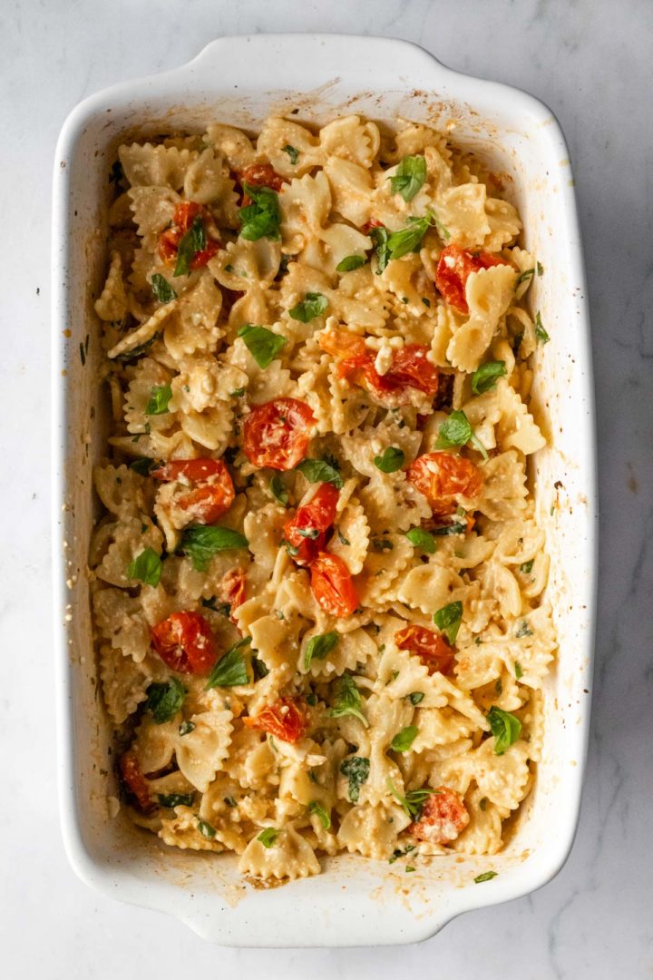 baked feta pasta on a baking dish with chopped basil on top