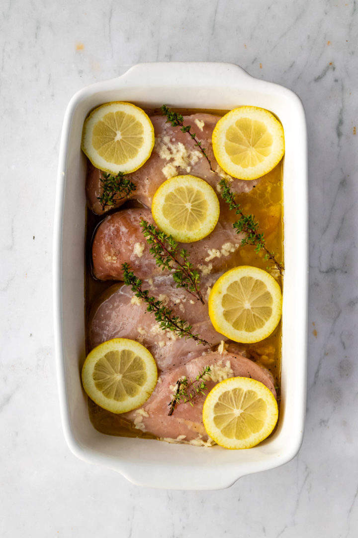chicken breasts seasoned on a baking dish before going to the oven