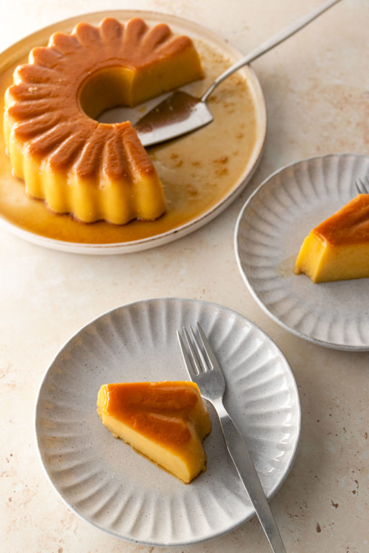 one plate with coconut pudding and two smaller ones with one slice of pudding each
