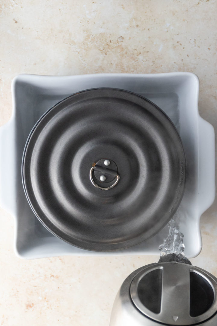 pouring boiling water inside a baking dish