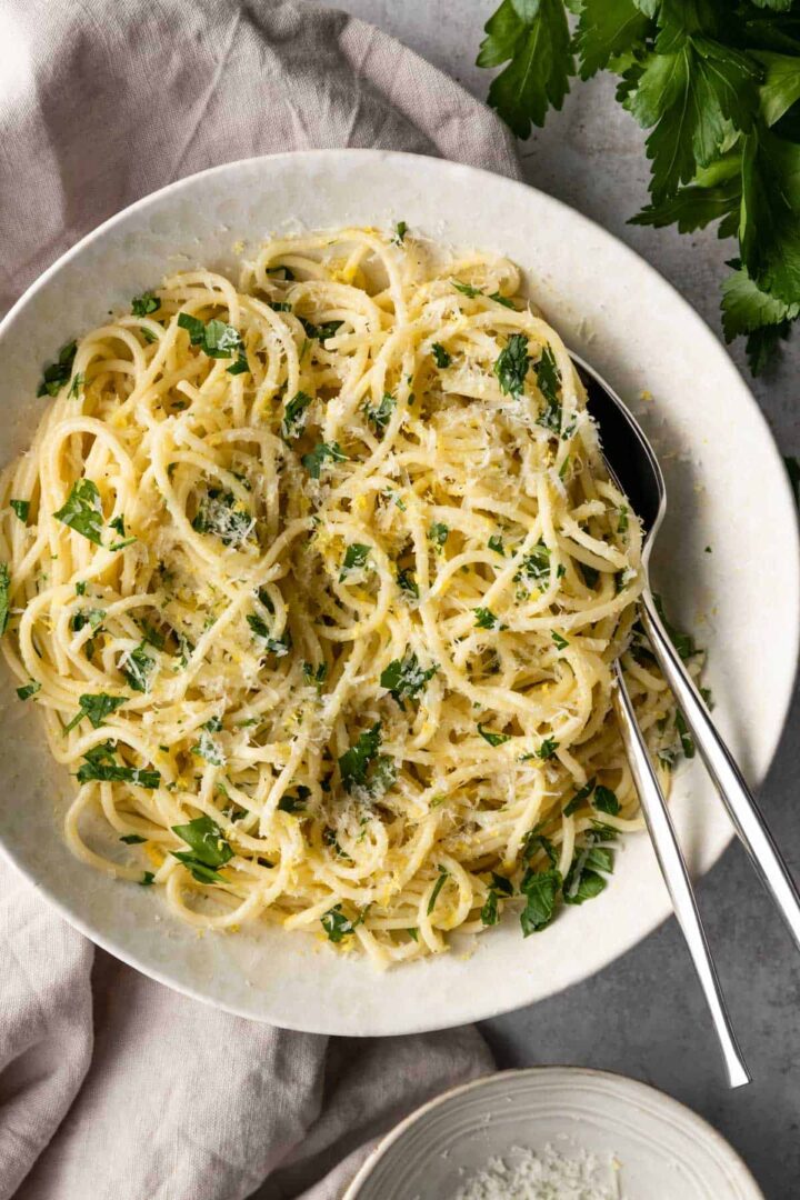 a bowl with lemon pasta, a fork and a spoon.