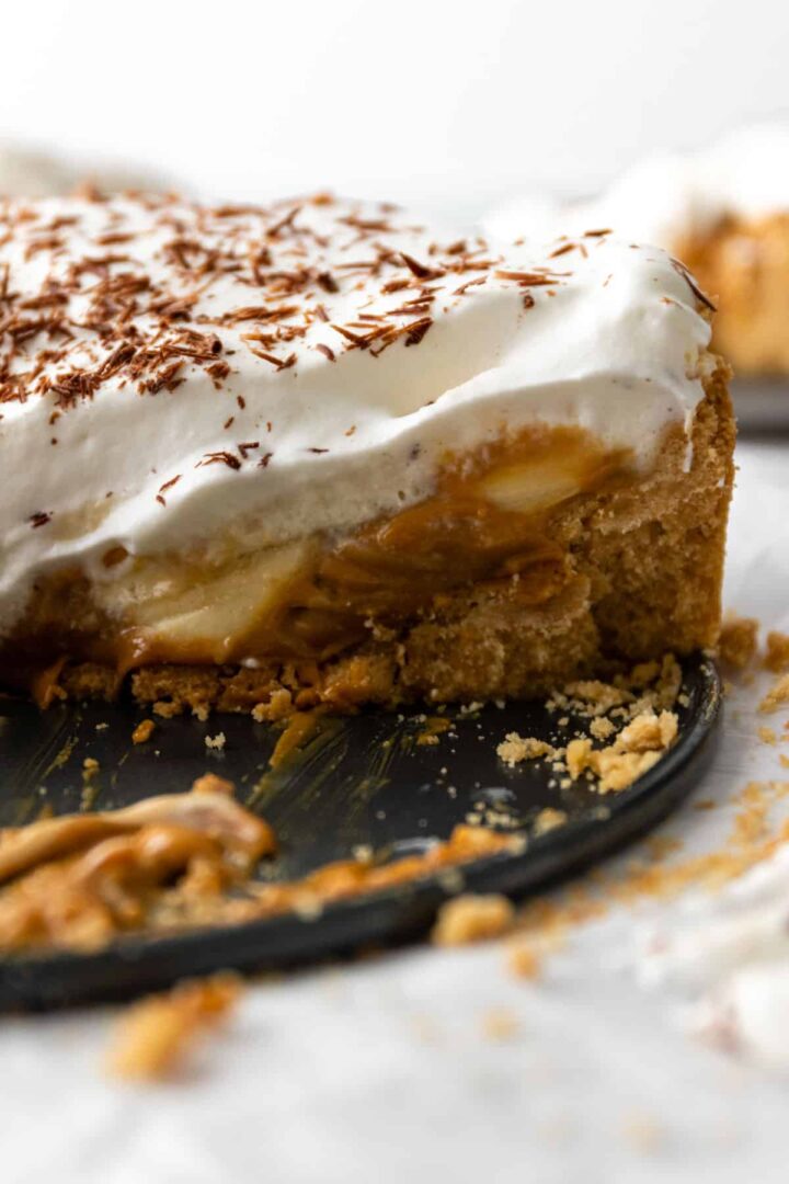 close look inside a banoffee pie with layers of dulce de leche, sliced bananas and whipped cream