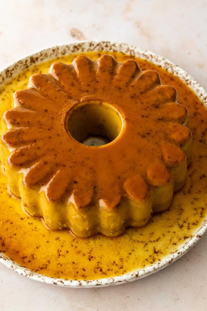 a pumpkin flan served on a plate with caramel sauce on top