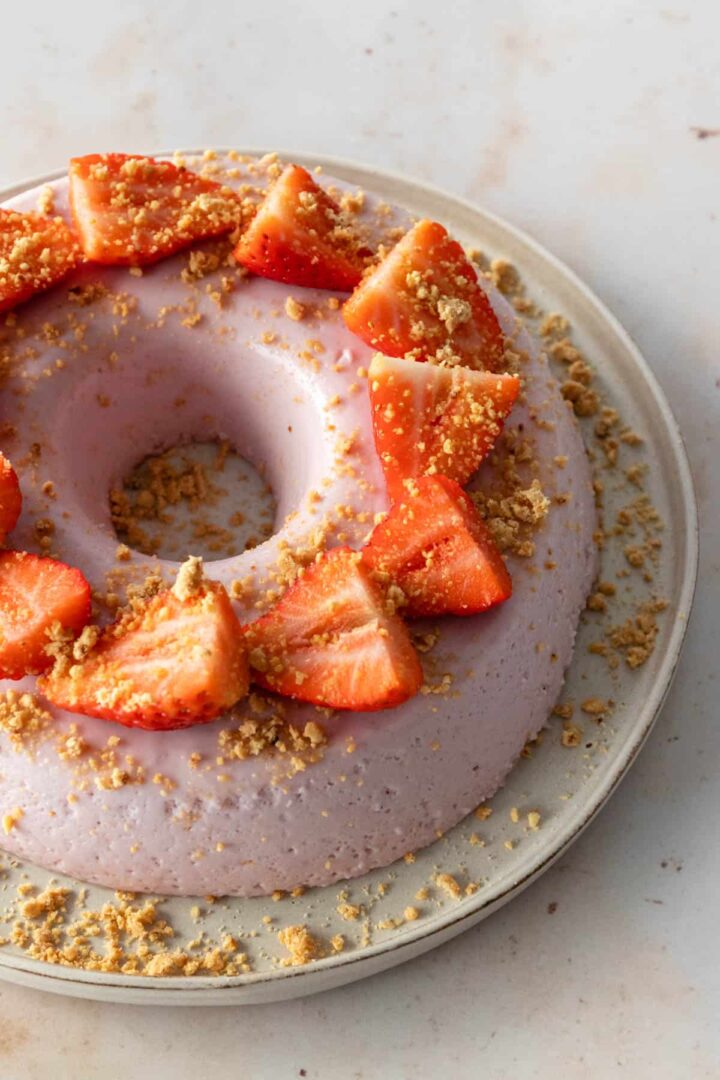 one plate with a strawberry pudding cake with sliced strawberries on top