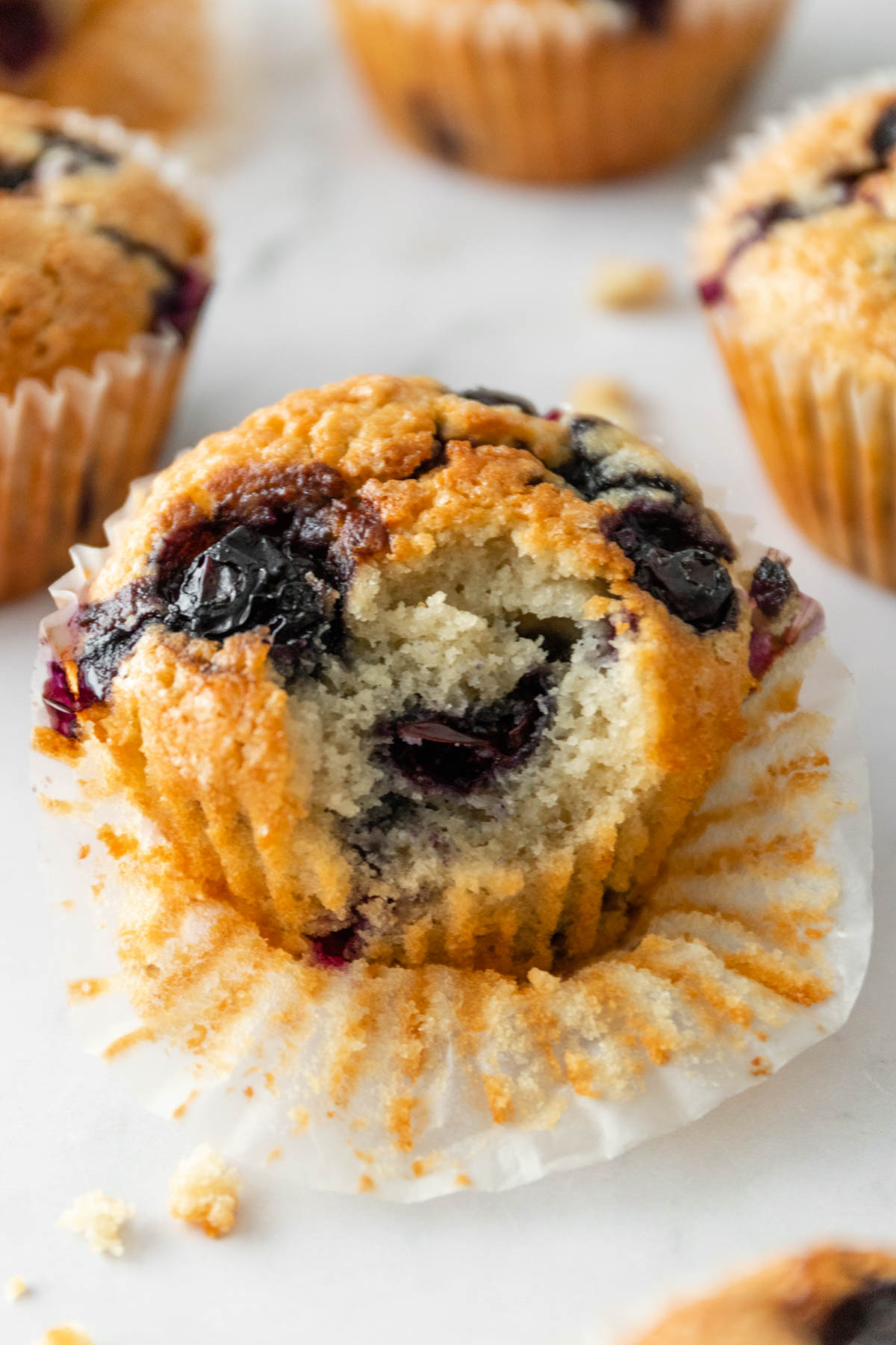 a bitten blueberry muffin on top of a marble board