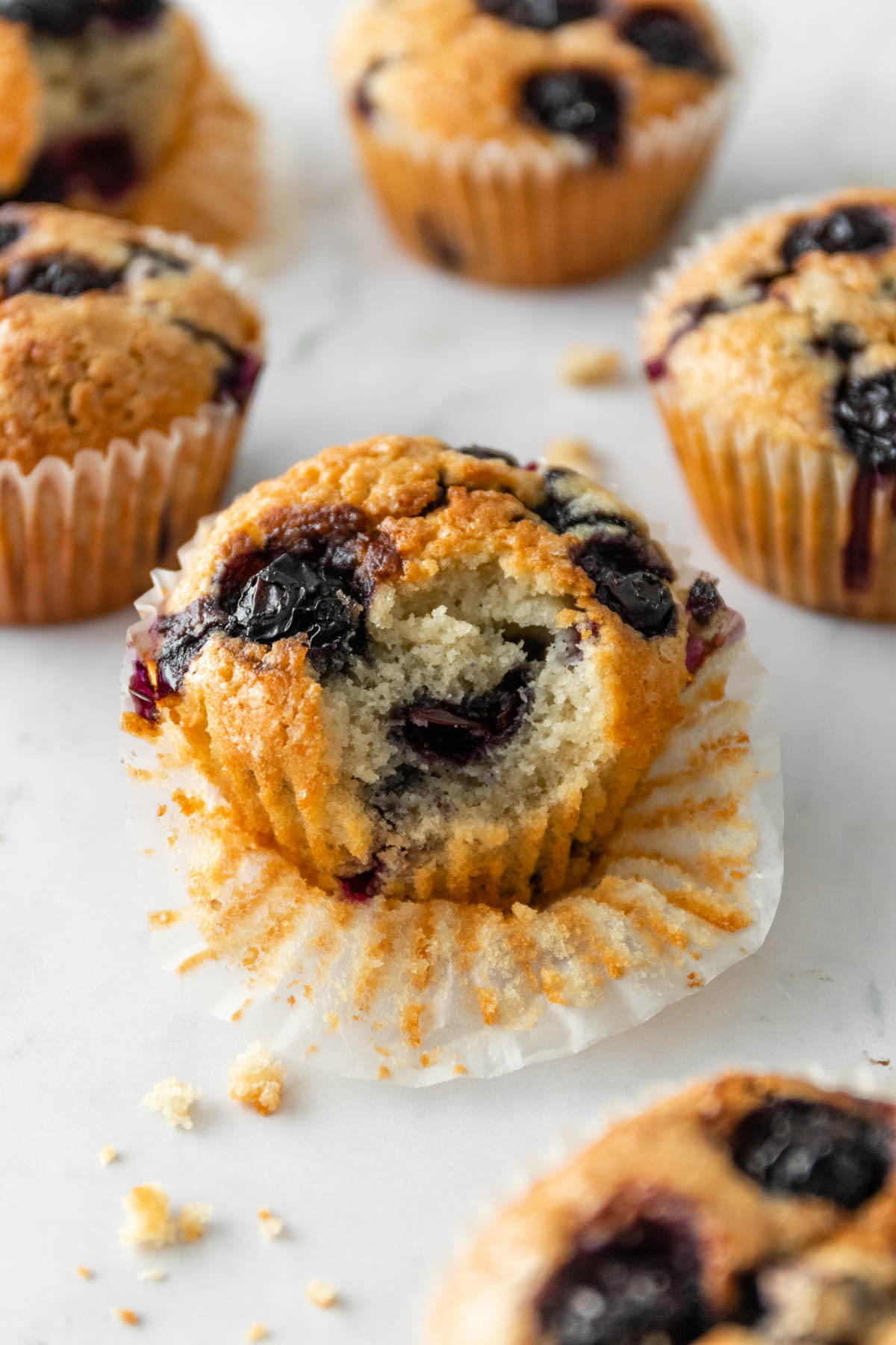 blueberry muffins on a marble board, on of them was bitten