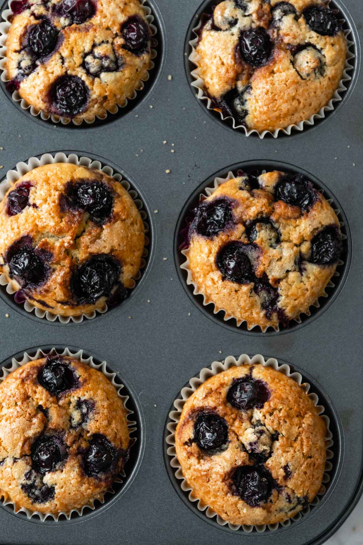 muffins on a muffin tin right after being removed from the oven