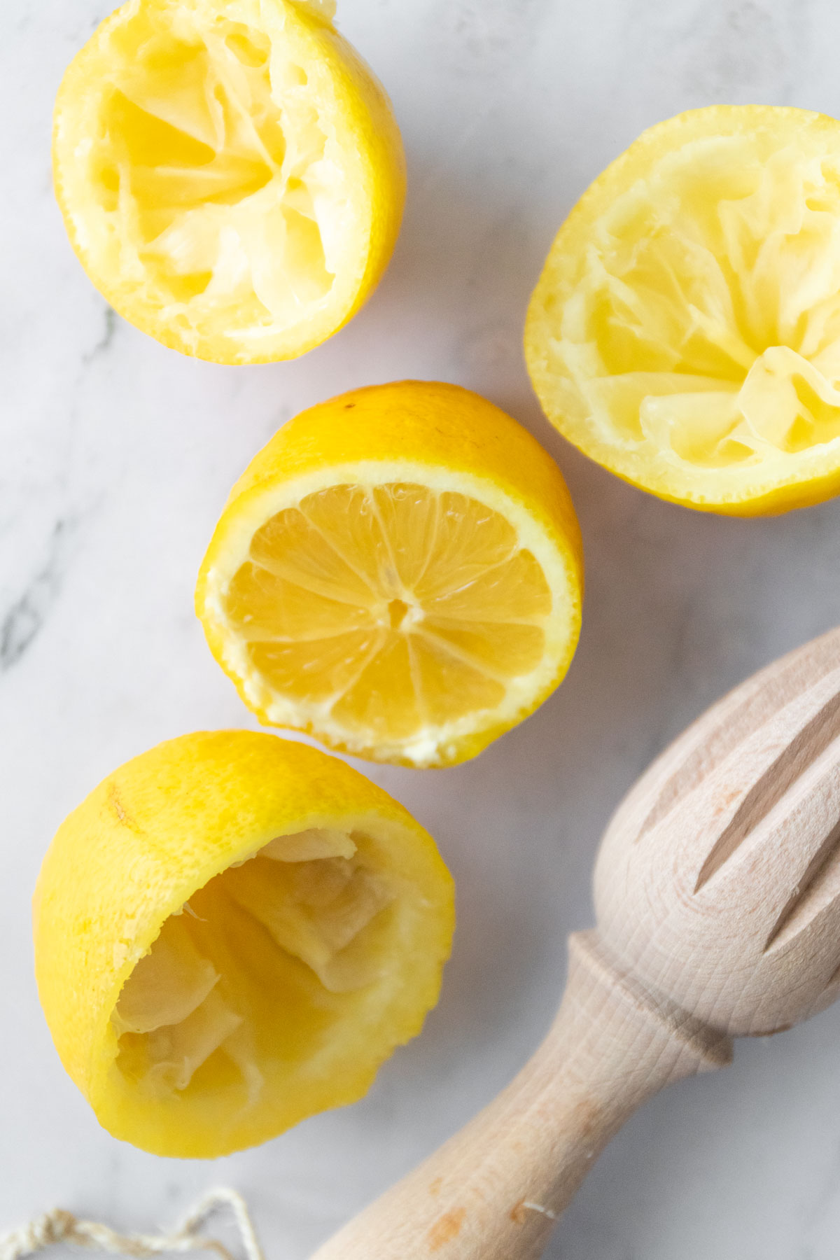 lemon halves and a utensil for squeezing lemon juice
