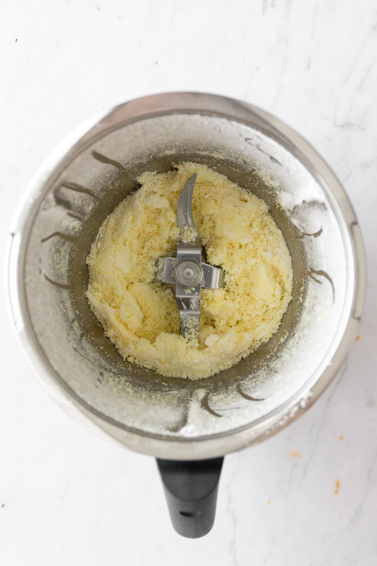 pulverized sugar and grated lemon zest inside the Thermomix bowl