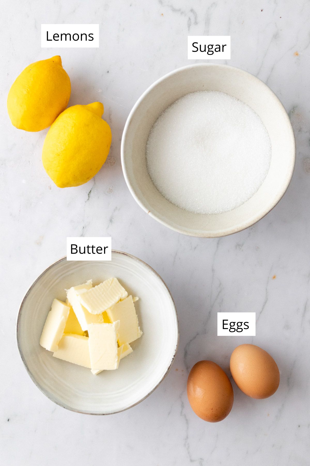 ingredients to make lemon curd on a marble board